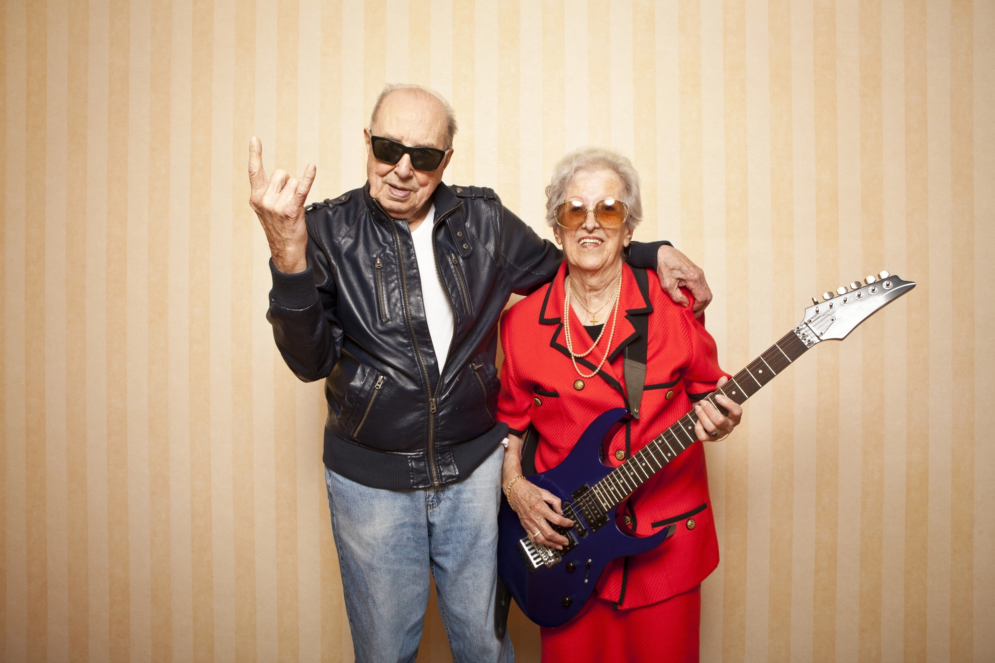 Älteres Paar als Rocker mit E-Gitarre und Lederjacke. Erschienen in metallzeitung 1/13.