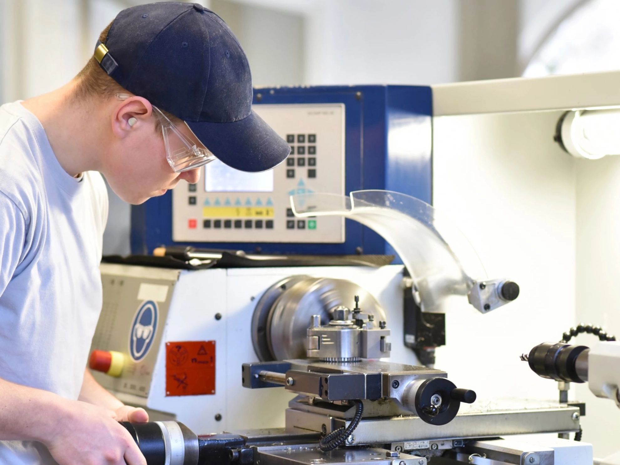 junger Mann arbeitet an einer Drehmaschine