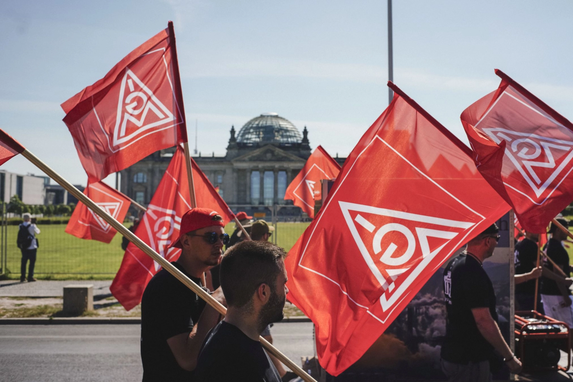 Metaller laufen mit IG Metall-Fahnen am Bundestag in Berlin vorbei zur FairWandel-Kundgebung